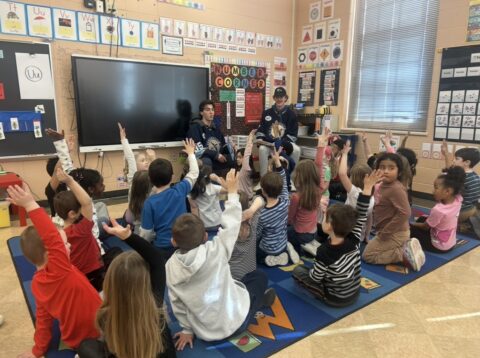 Children raising hands in classroom