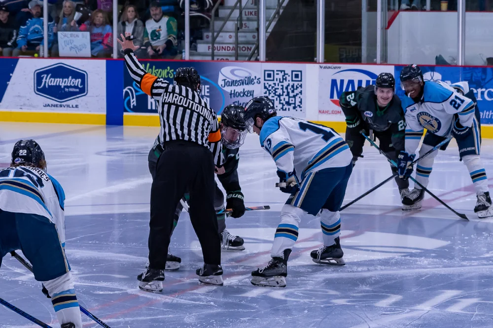 ref dropping puck for faceoff
